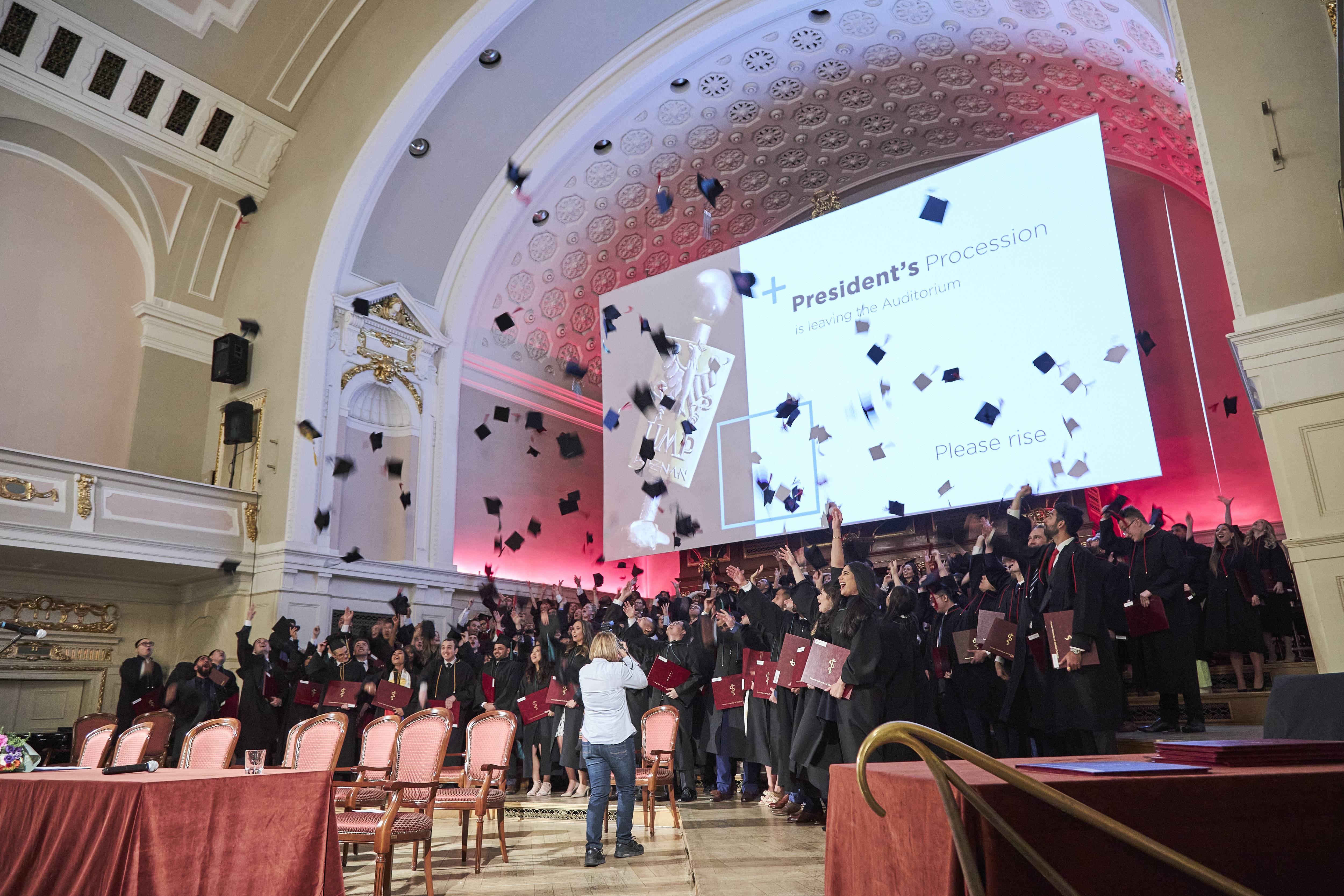 Group photo showing the moment of jubilation with graduating caps in the air