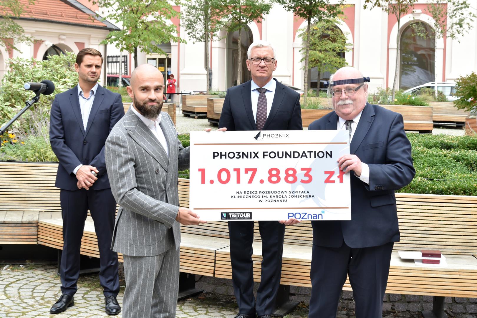 Kulczyk and Daszkiewicz holding a check, president Jaśkowiak in the background